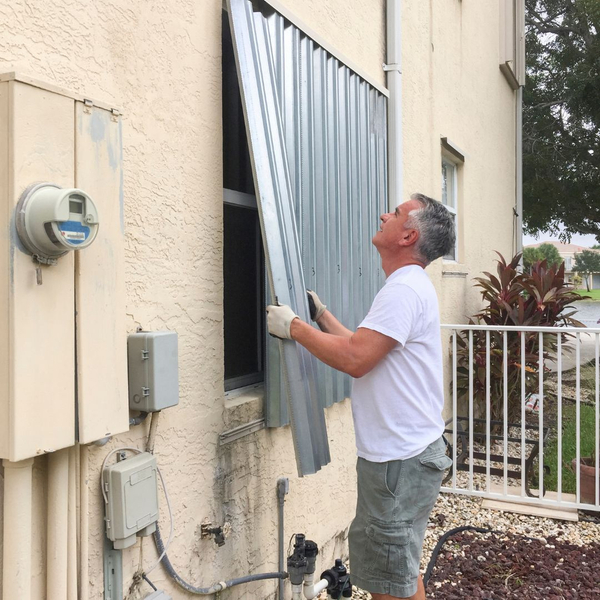 man working on hurricane shutters 