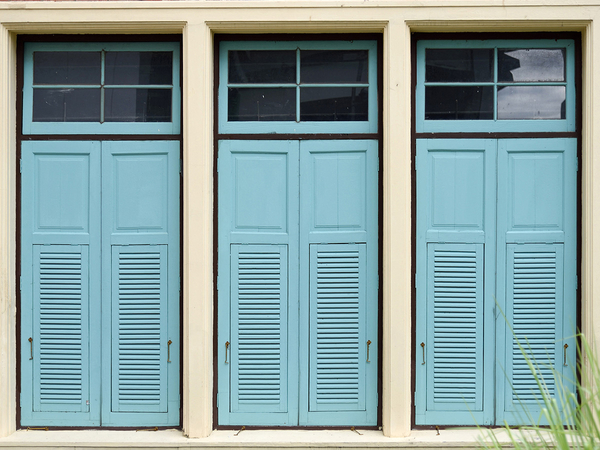 Teal storm shutters on a home's windows