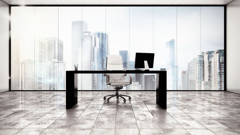 Empty office with a white chair and a view of a city from the windows