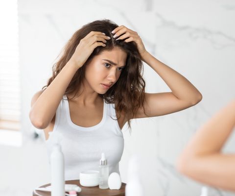 woman inspecting scalp