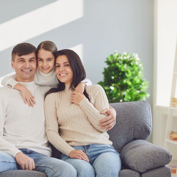 Family smiling on a couch