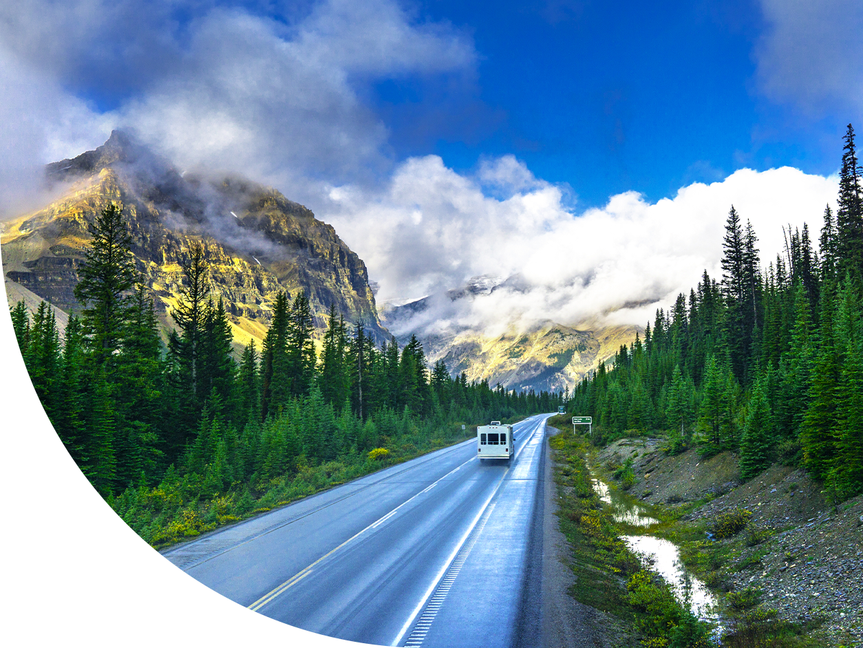 RV driving down open road in a mountain landcape