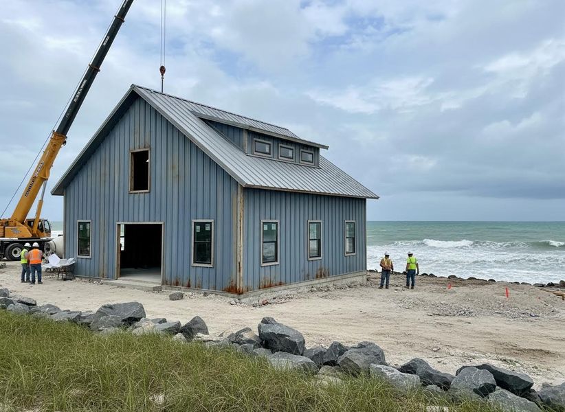 Coastal barn-style home construction with crane