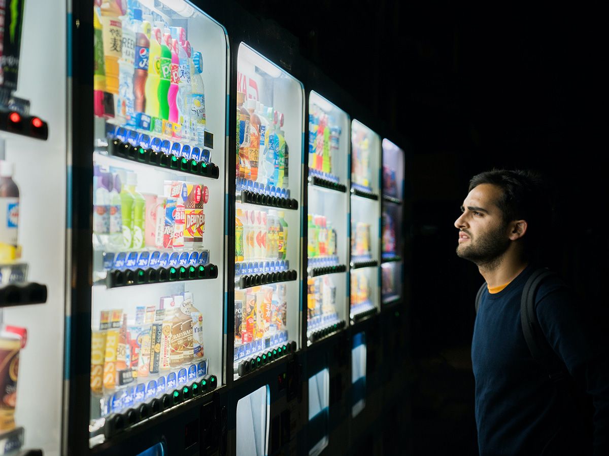 Image of a man looking at a row of vending machines