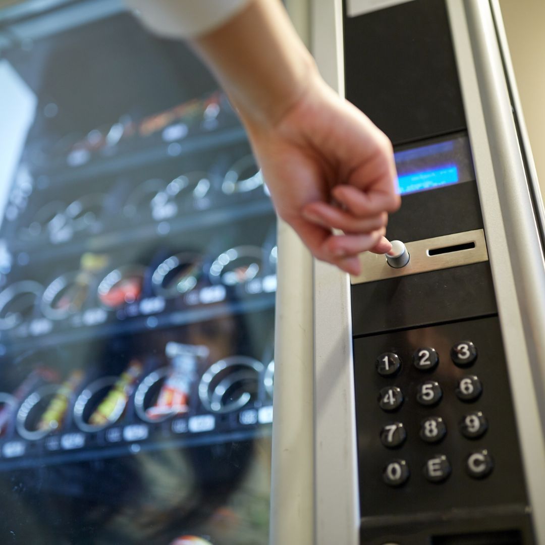 Person pushing button on vending machine