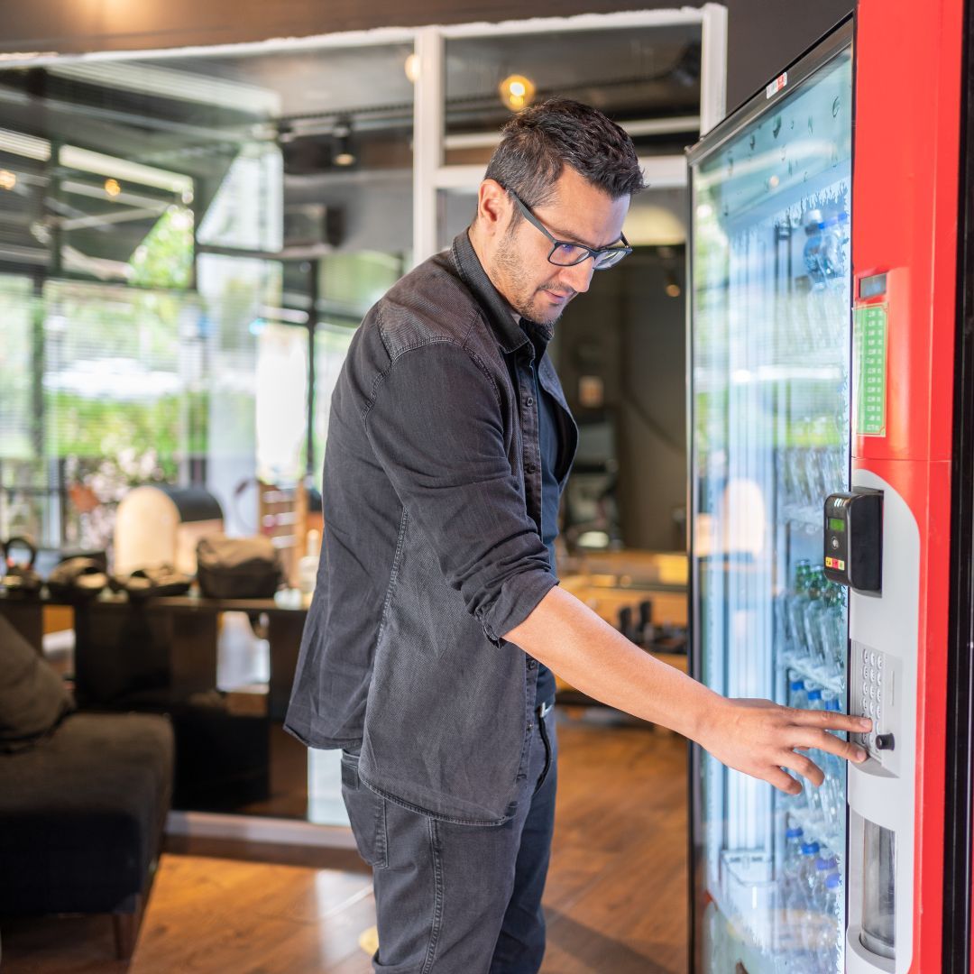 A man getting a drink from a vending machine in his office