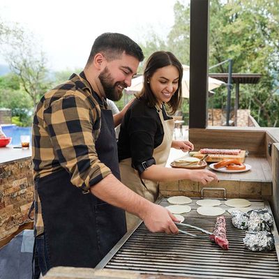 couple grilling at outdoor kitchen