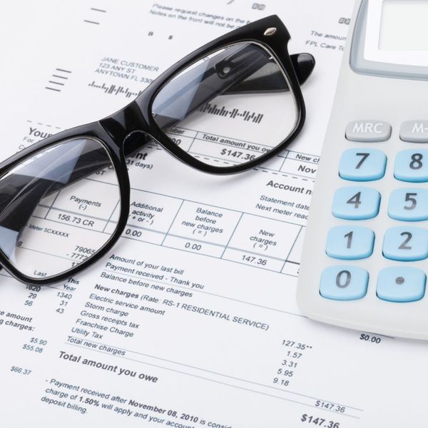 Glasses and a calculator on top of a bill