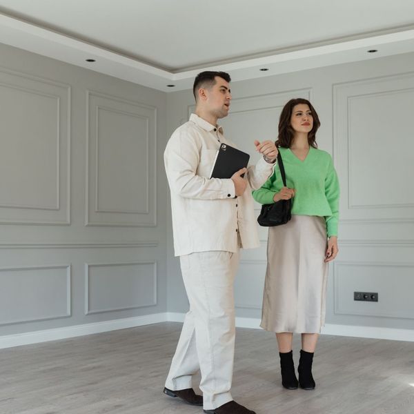A professional real estate agent is showing a woman the basement of a new home