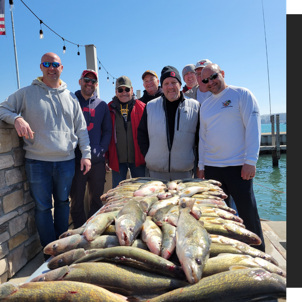 group of men standing behind a pile of the fish they caught group of men standing behind a pile of the fish they caught