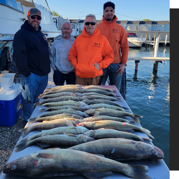 group standing behind their caught fish on a table group standing behind their caught fish on a table