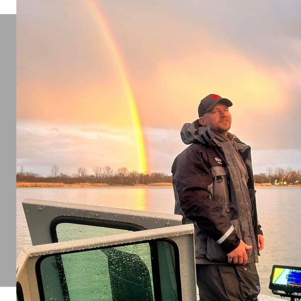 man standing on fishing boat with a rainbow in the background man standing on fishing boat with a rainbow in the background