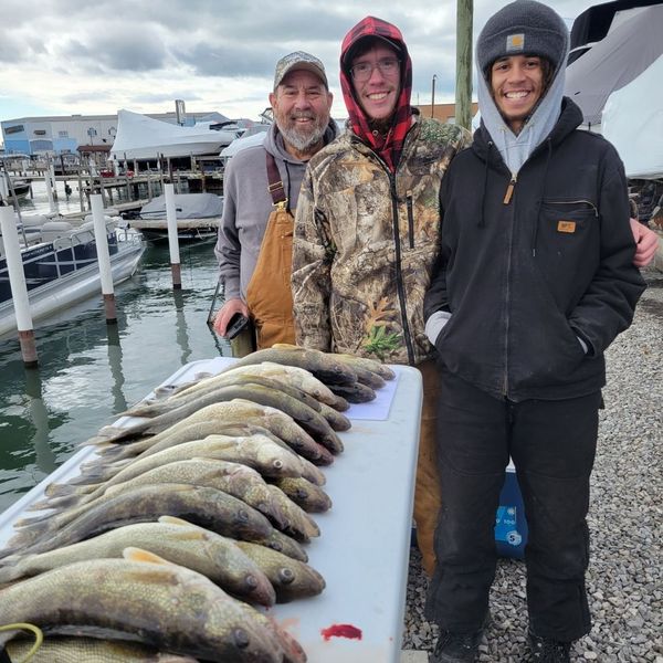 happy fishers, walleyes lined up in foreground
