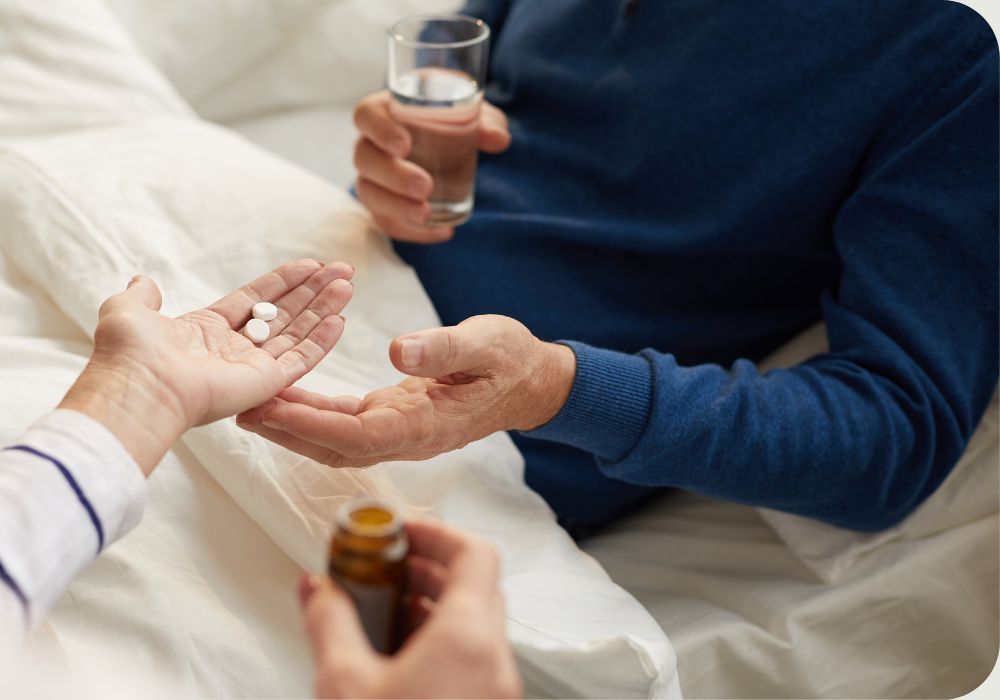 Person giving older person pills