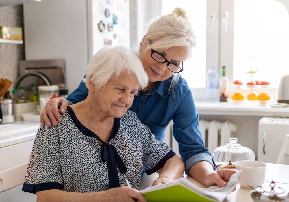 a middle aged woman looking at paperwork with her older mother