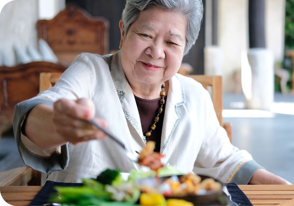 Elderly woman eating at a table