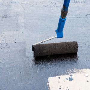 Concrete staining being rolled on to freshly sealed concrete