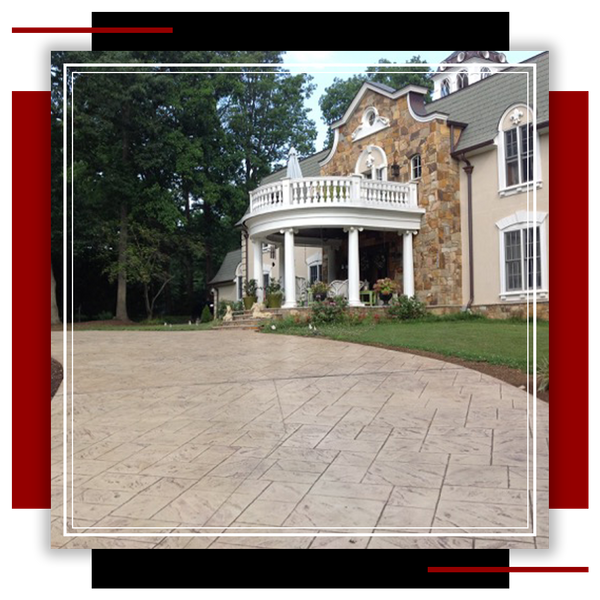 Large home with multiple faux natural stone accents and concrete driveway