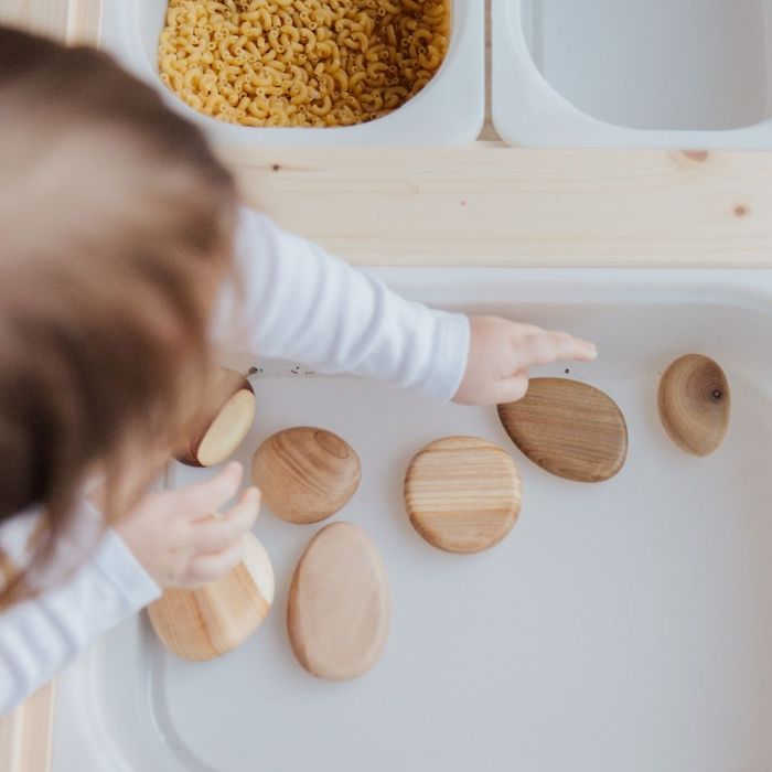 A preschooler independently selecting their next activity of some wooden stones