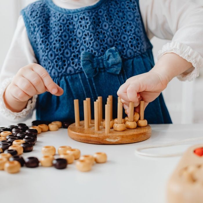 a child playing with a wooden puzzle toy