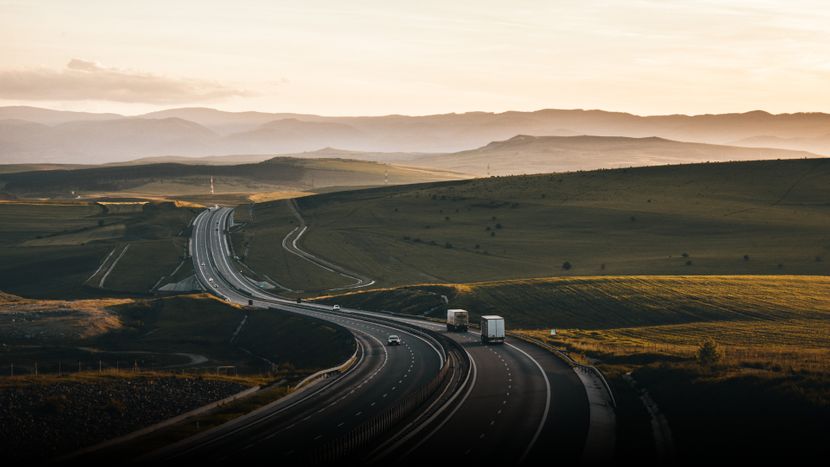 Two delivery trucks on a highway