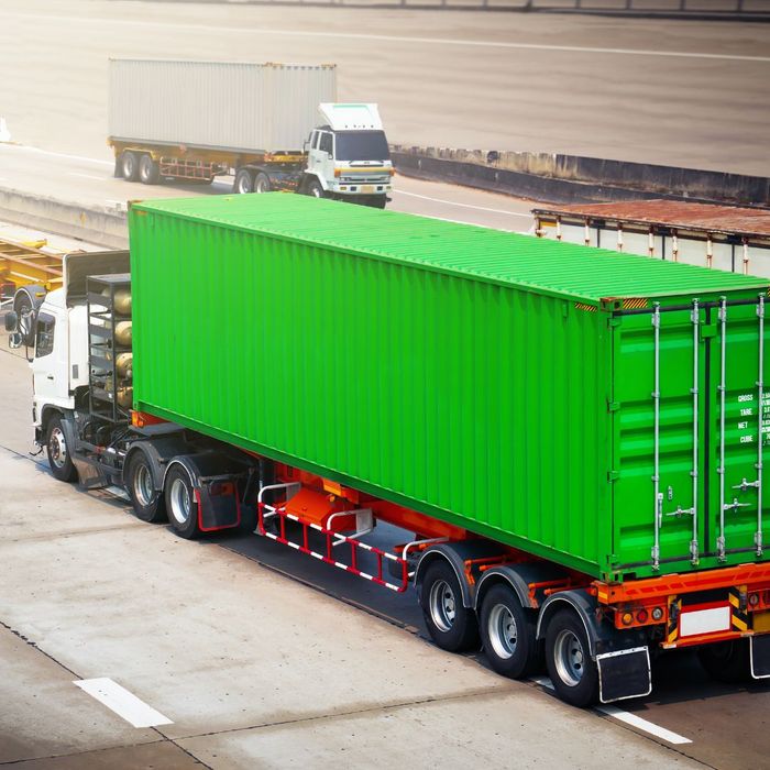 A semi truck with a green cargo container 