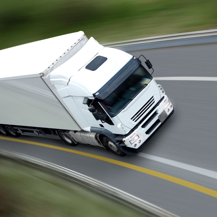 white truck speeds down road