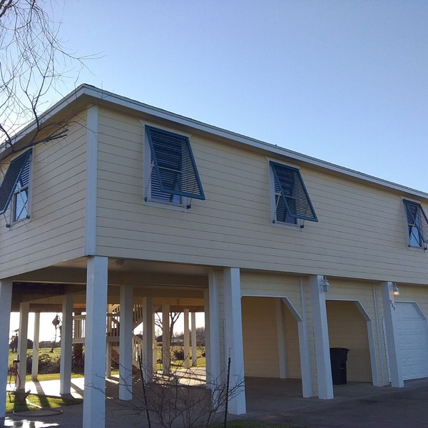 Bahama shutters on multiple windows on a house