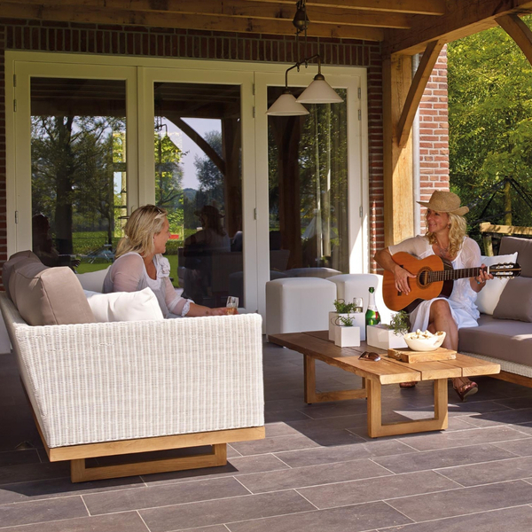 Women playing guitar while sitting on their patio