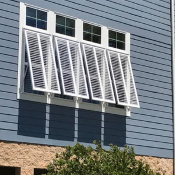 Bahama shutters on the outside of four windows
