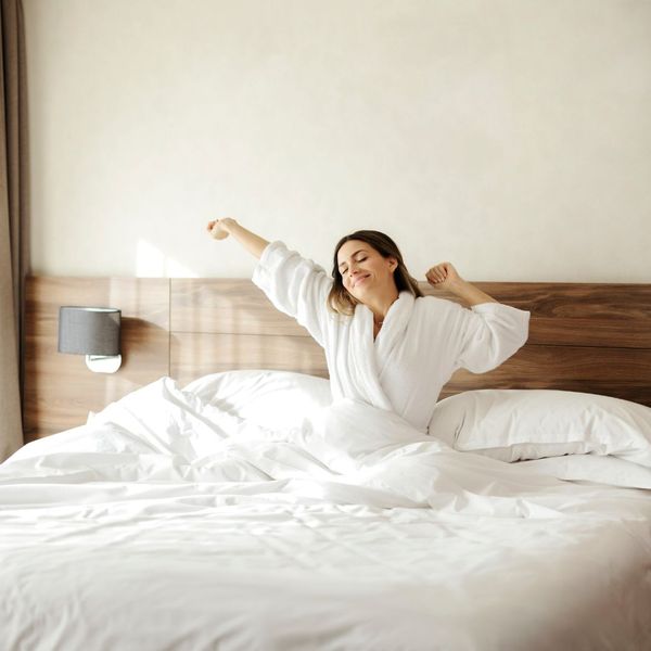 Woman waking up happy in bed