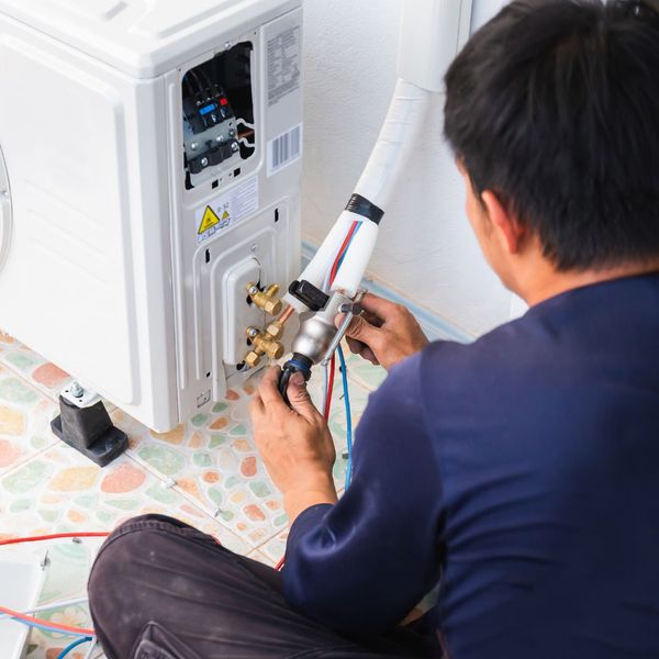 HVAC tech conducting AC maintenance 