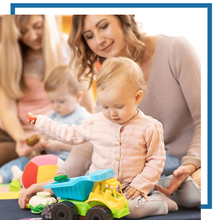 caretaker helping baby play with toys