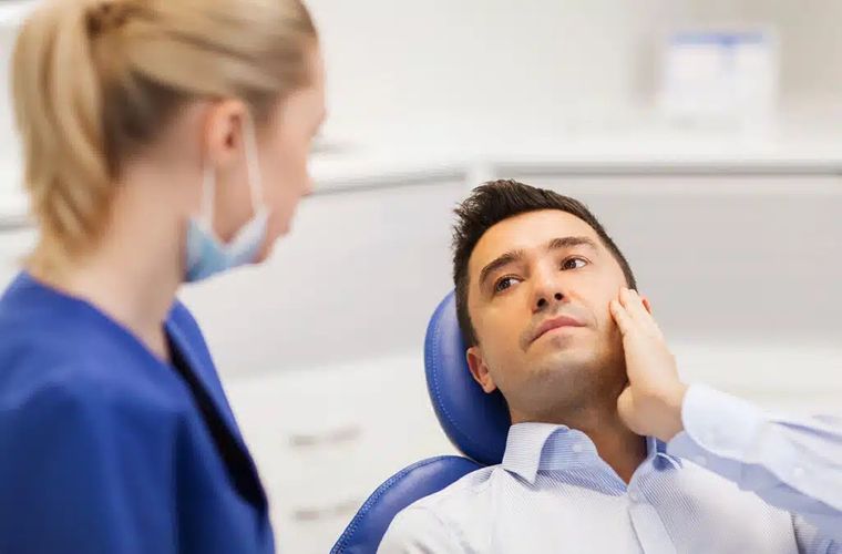 man with dental pain speaking with dentist man with dental pain speaking with dentist