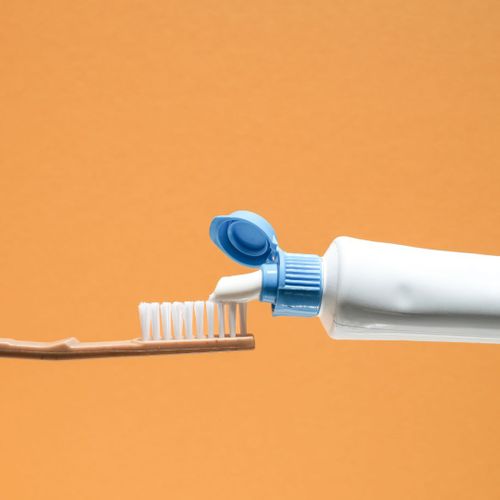putting toothpaste on a toothbrush
