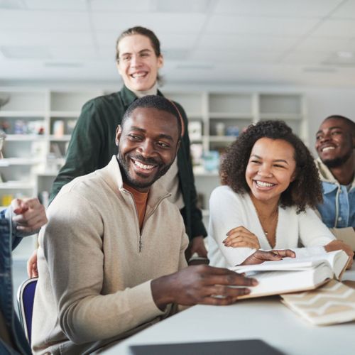 Group of diverse, happy friends laughing in library