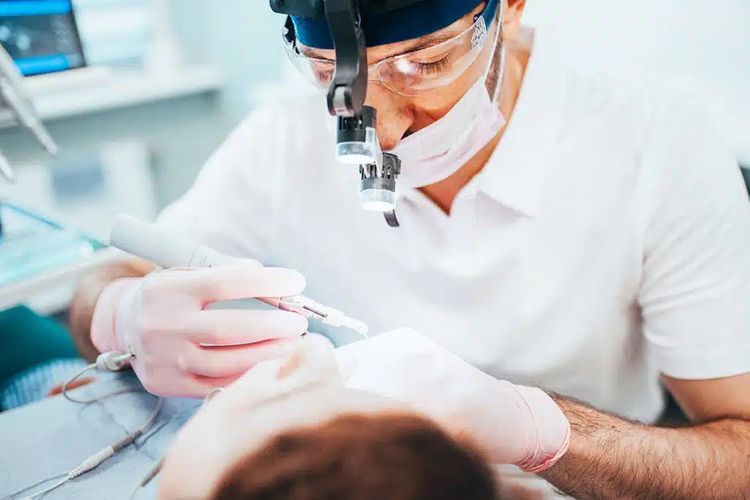 Dentist performing root canal Dentist performing root canal