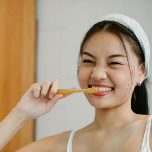 girl brushing her teeth and smiling
