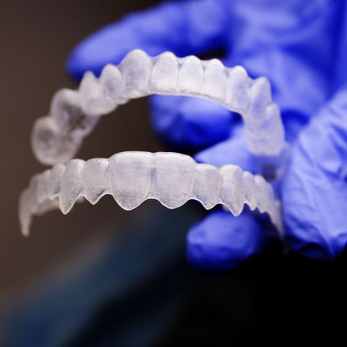 dentist holding Invisalign braces dentist holding Invisalign braces