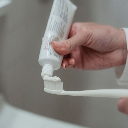 putting toothpaste on toothbrush