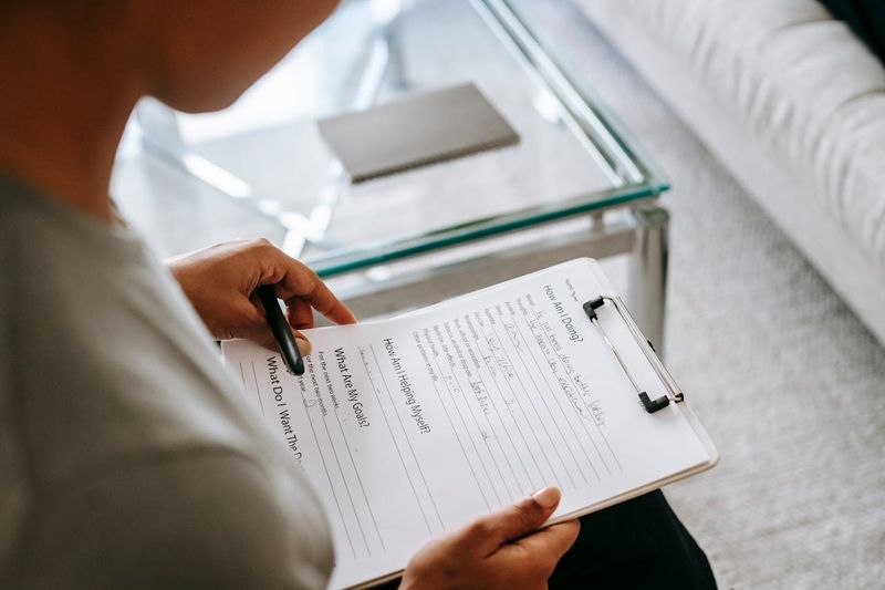 therapist reading notes on clipboard