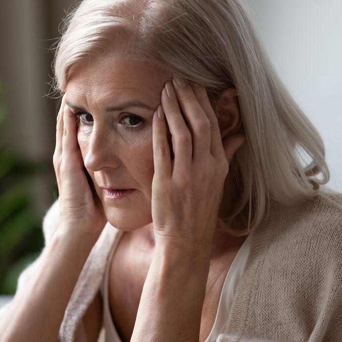 Image of a scared looking woman holding her head