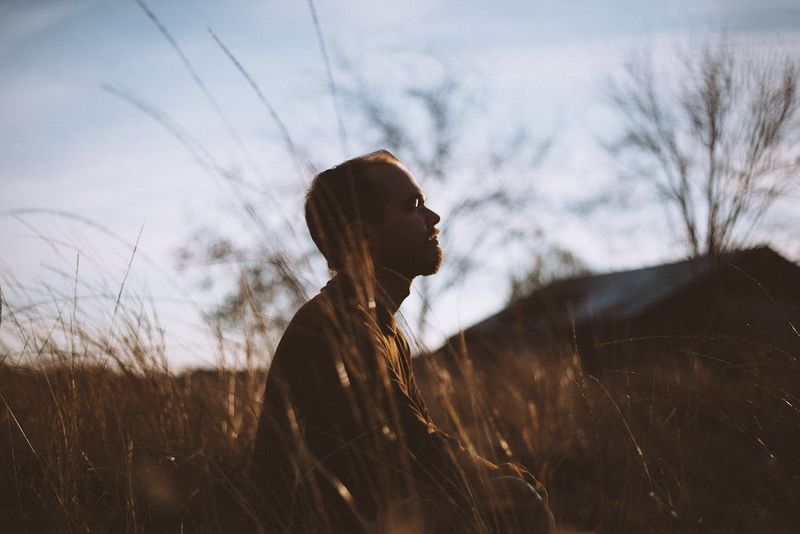 Man Sitting on Grass Field at Daytime