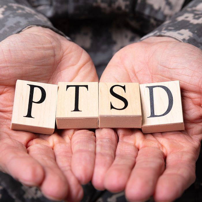 a man in uniform holding blocks that say PTSD