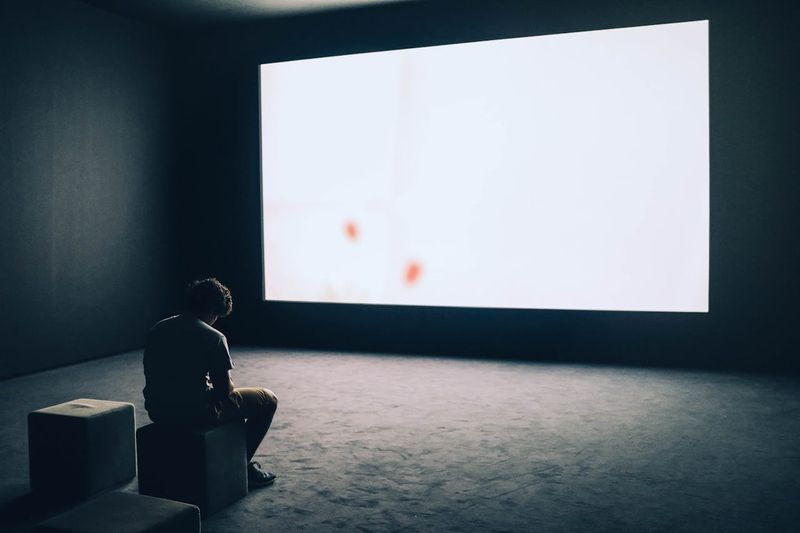 teenage boy alone in a dark room with open window