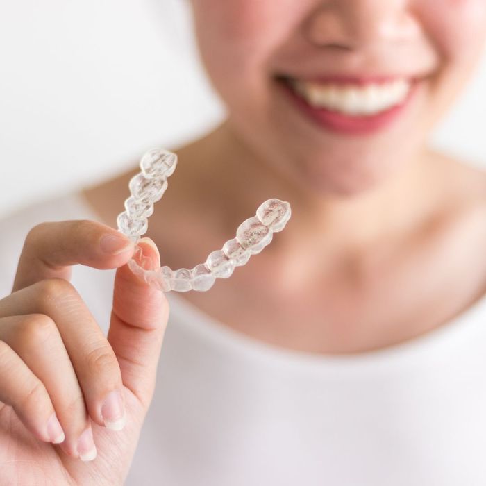 woman holding up Invisalign retainer