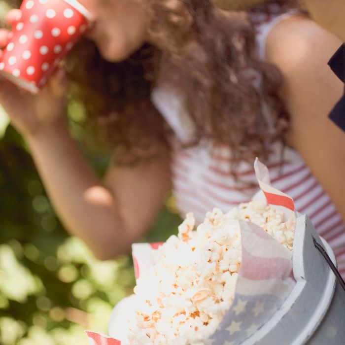 girl eating from a bucket of popcorn