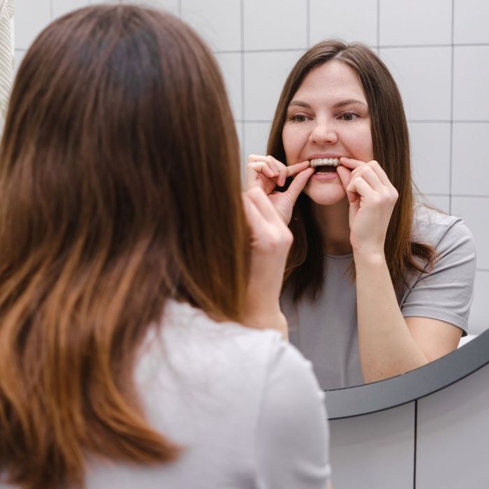 woman putting in clear braces