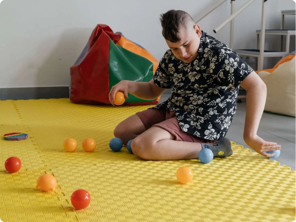 mentally disabled child playing with plastic balls