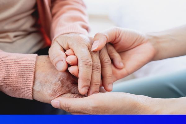 woman holding elderly persons hands